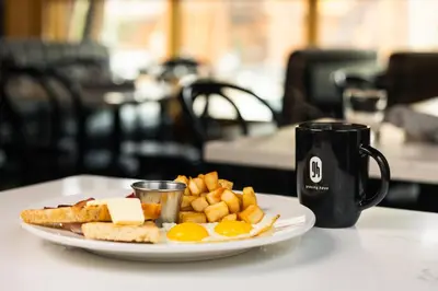 a plate of eggs and french fries and a coffee mug at Gravity Haus Truckee-Tahoe in Truckee