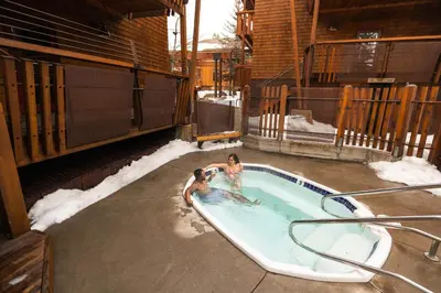 two people in a swimming pool in the snow at Gravity Haus Truckee-Tahoe in Truckee