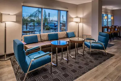 a living room with a couch and chairs and tables at TownePlace Suites by Marriott Merced in Merced