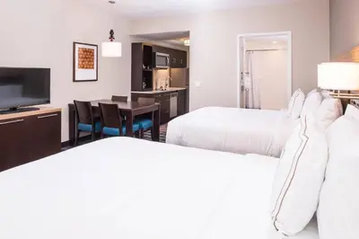a hotel room with two beds and a dining room at TownePlace Suites by Marriott Merced in Merced