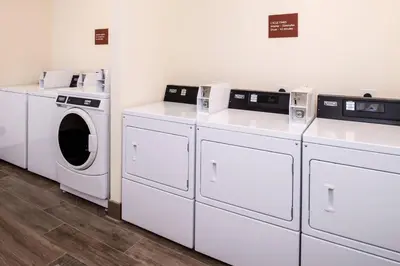 a laundry room with white washers and dryers at TownePlace Suites by Marriott Merced in Merced