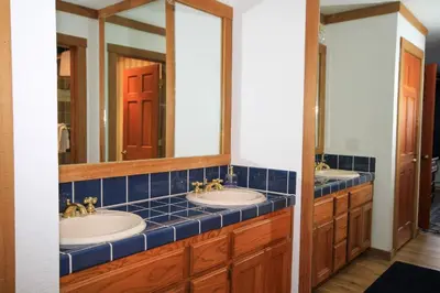 a bathroom with two sinks and two mirrors at Mountainback 116 LoftCorner in Mammoth Lakes