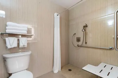 a bathroom with a toilet and a shower with towels at Best Western Plus Sparks-Reno Hotel in Reno