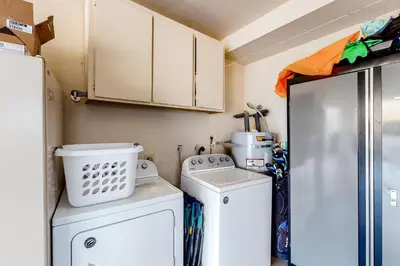 a kitchen with a washer and dryer and a refrigerator at Creekside Cabin in Groveland