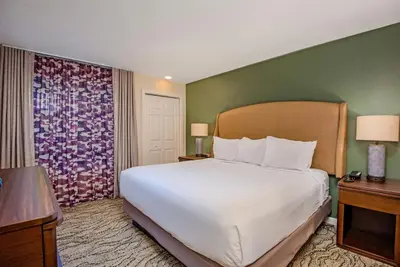 a bedroom with a large white bed and a green wall at WorldMark Angels Camp in Angels Camp