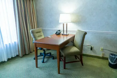 a room with a desk and two chairs and a lamp at Hotel Piccadilly in Fresno
