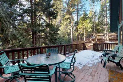 a table and chairs on a deck with snow at Pine Paradise in Camp Connell
