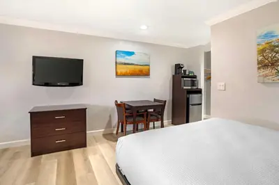 a bedroom with a bed and a desk and a television at Best Western Inn in Merced