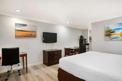 a bedroom with a bed and a desk and a tv at Best Western Inn in Merced