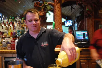 a man standing at a bar pouring a drink at Double Eagle Resort and Spa in June Lake