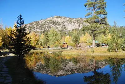 a reflection of a mountain in a lake with a cabin at Double Eagle Resort and Spa in June Lake
