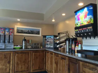 a kitchen with a bar with a tv on the wall at Oakhurst Lodge in Oakhurst