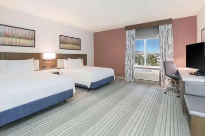 a hotel room with two beds and a flat screen tv at Hilton Garden Inn Reno in Reno