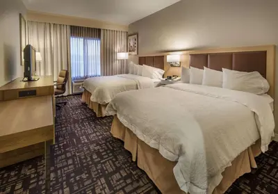 a hotel room with two beds and a television at Hampton Inn & Suites Reno in Reno