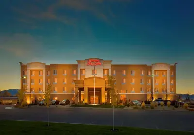 a hotel building with a sign on the front of it at Hampton Inn & Suites Reno in Reno