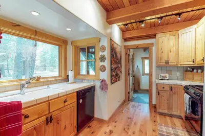 a kitchen with wooden cabinets and a large window at Timeless in Tahoma in Tahoma