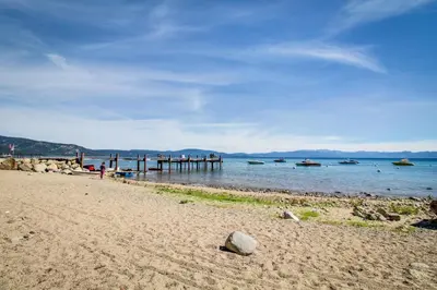 a beach with a pier and boats in the water at Timeless in Tahoma in Tahoma