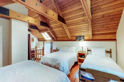 two beds in a room with wooden ceilings at Timeless in Tahoma in Tahoma