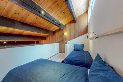a bedroom with two blue beds and wooden ceilings at Kingswood Retreat in Kings Beach
