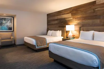 a hotel room with two beds and a chair at Hotel Azure in South Lake Tahoe