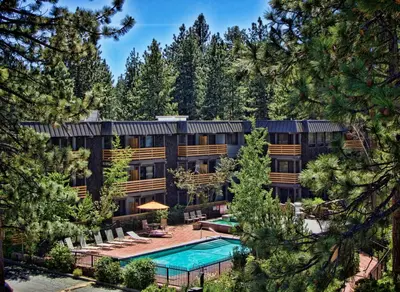 an exterior view of a resort with a pool and trees at Hotel Azure in South Lake Tahoe