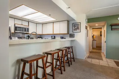 a kitchen with a row of bar stools at Bridges 107 in Mammoth Lakes