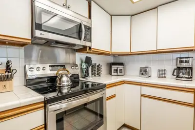 a kitchen with a stove and a microwave at Bridges 107 in Mammoth Lakes
