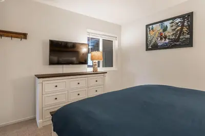 a bedroom with a bed and a flat screen tv at Bridges 107 in Mammoth Lakes
