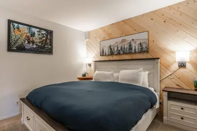 a bedroom with a bed and two pictures on the wall at Bridges 107 in Mammoth Lakes