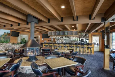 a restaurant with tables and chairs and a bar at Best Western Plus Yosemite Gateway Inn in Oakhurst