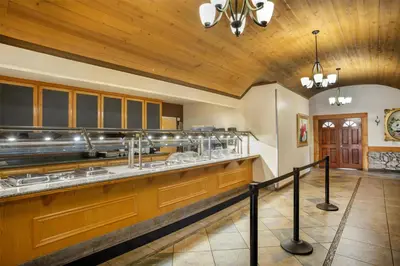 a large kitchen with wooden cabinets and a wooden ceiling at Best Western Plus Yosemite Gateway Inn in Oakhurst