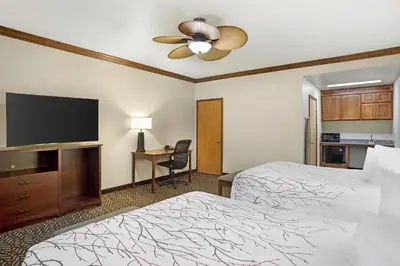 a hotel room with two beds and a flat screen tv at Best Western Plus Yosemite Gateway Inn in Oakhurst