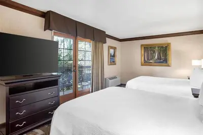 a hotel room with two beds and a flat screen tv at Best Western Plus Yosemite Gateway Inn in Oakhurst