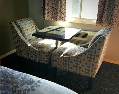 a room with two chairs and a table and a window at Garden View Inn in Fresno