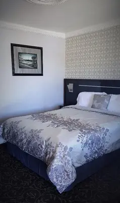 a bedroom with a bed with a blue and white comforter at Garden View Inn in Fresno