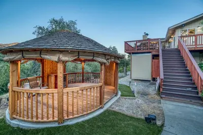 a gazebo in a yard next to a house at A Bed of Roses in Yosemite Forks