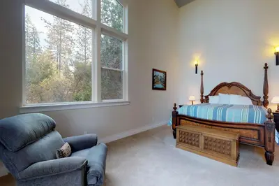 a bedroom with a bed and a chair and a window at Pine Mountain Getaway (02-461) in Groveland