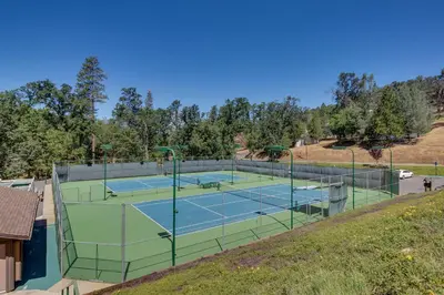 a tennis court on a hill with two tennis courts at Cozy Chalet (15-013) in Groveland
