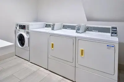 a laundry room with three washes and a washer and dryer at Holiday Inn Express Stockton Southeast by IHG in Stockton