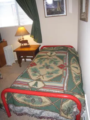 a bedroom with a bed and a table with a lamp at Sierra Manor in Mammoth Lakes