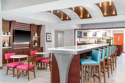 a kitchen with a bar with colorful chairs at Hampton Inn & Suites Sacramento-Auburn Boulevard in Sacramento