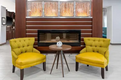 two yellow chairs and a table and a fireplace at Hampton Inn & Suites Sacramento-Auburn Boulevard in Sacramento