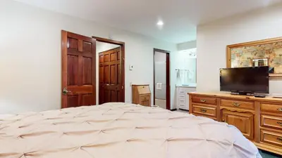 a bedroom with a large bed and a flat screen tv at Winterset 12 Condo in Mammoth Lakes