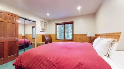 a bedroom with a large bed with a red blanket at Winterset 12 Condo in Mammoth Lakes