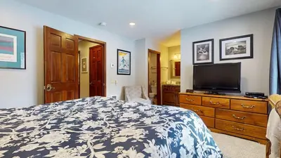a bedroom with a bed and a flat screen tv at Woodlands #33 Condo in Mammoth Lakes