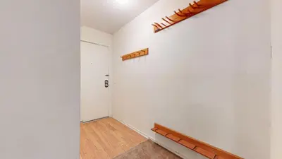 a hallway with a wooden bench and a white wall at Summit Condominium #273 Condo in Mammoth Lakes