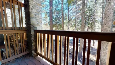 a balcony of a cabin with a view of the woods at Summit Condominium #267 Condo in Mammoth Lakes