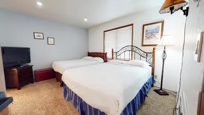 a bedroom with two beds and a flat screen tv at Helios North #5 Condo in Mammoth Lakes