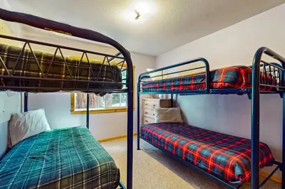 two bunk beds in a small room with a bed at Happy Family Cozy Cabin in Truckee