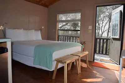 a bedroom with a large bed and a balcony at Yosemite RV Resort in Coarsegold